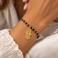 Bransoletka z pozłacanych kulek i fasetowanych, granatowych koralików z zawieszką ręką Fatimy (B26/TAL/48AU) - Nagłówek – kopia – kopia - 2026-10-06T135002.457.png